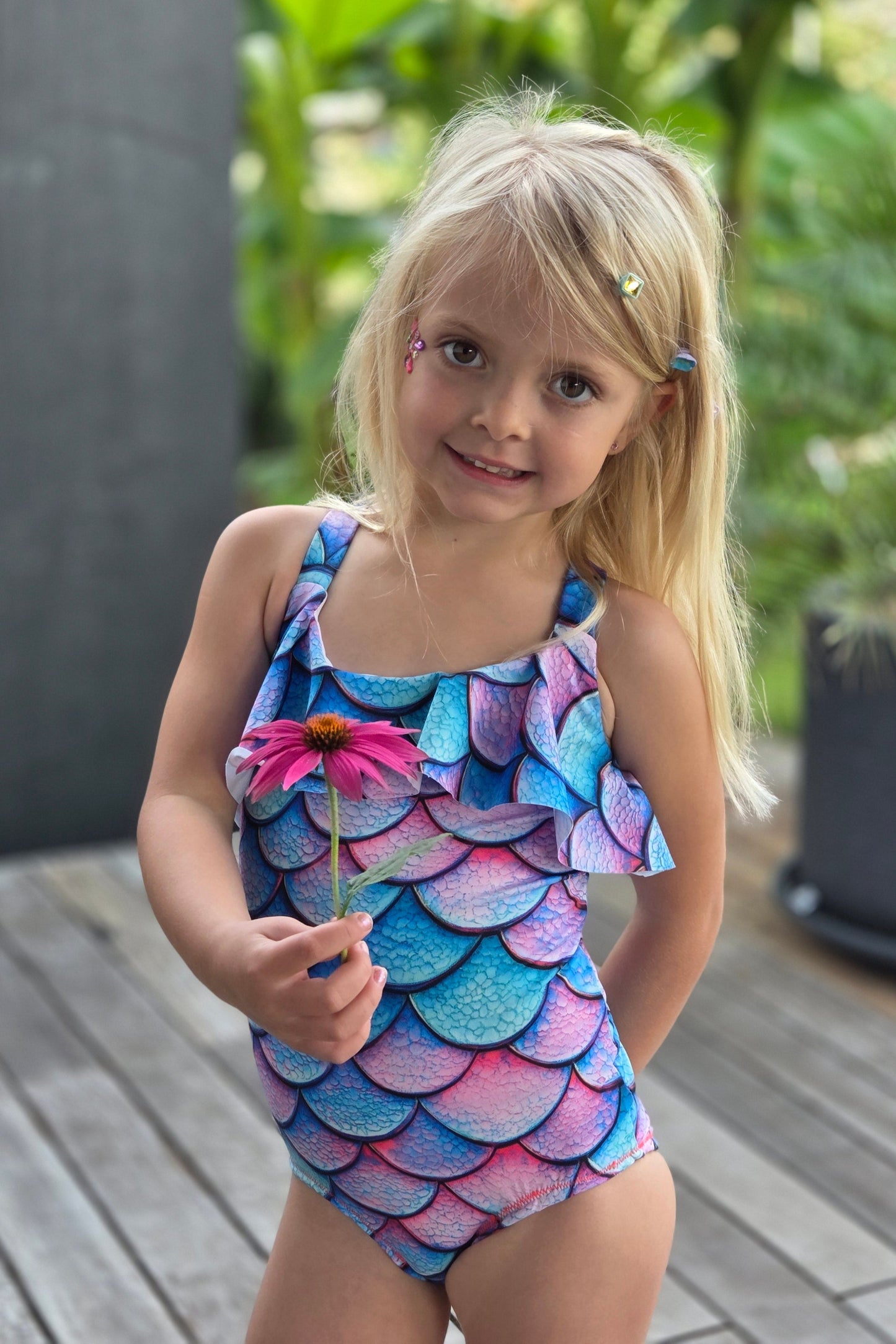 Child wearing a colorful mermaid-themed dress outdoors