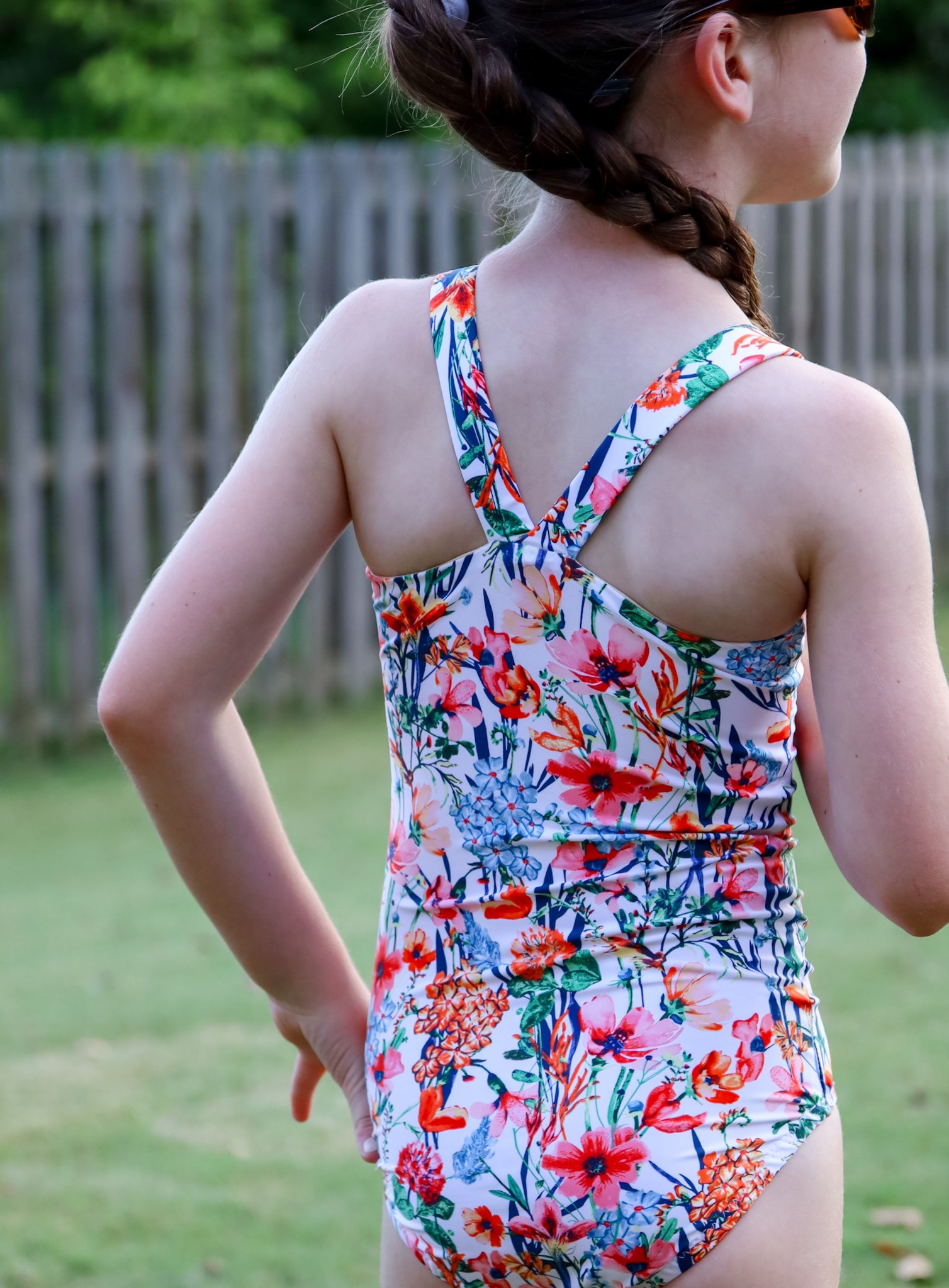 Child wearing a colorful floral swimsuit outdoors