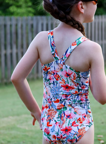 Child wearing a colorful floral swimsuit outdoors