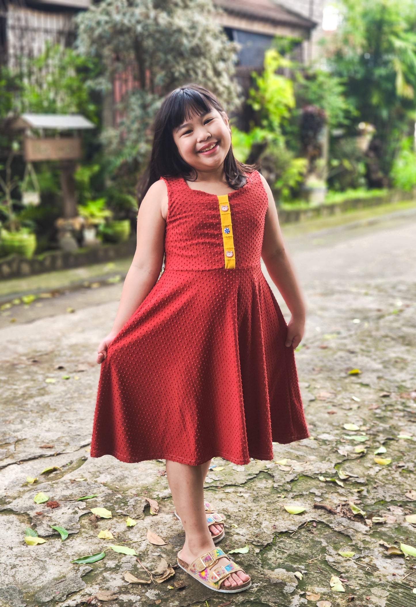 Young girl in a red dress textured knit fabric, swiss dot